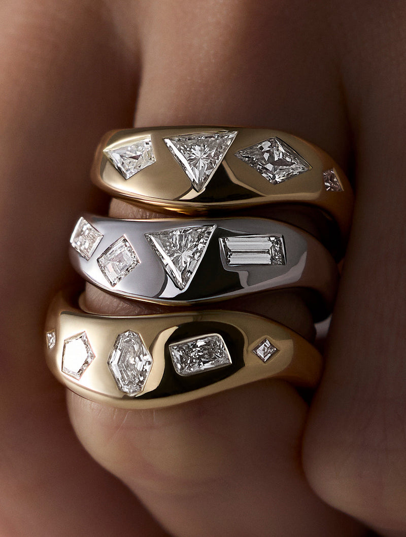 Three signature LEIL star cluster lab diamond rings in 18k yellow and white gold stacked on a finger