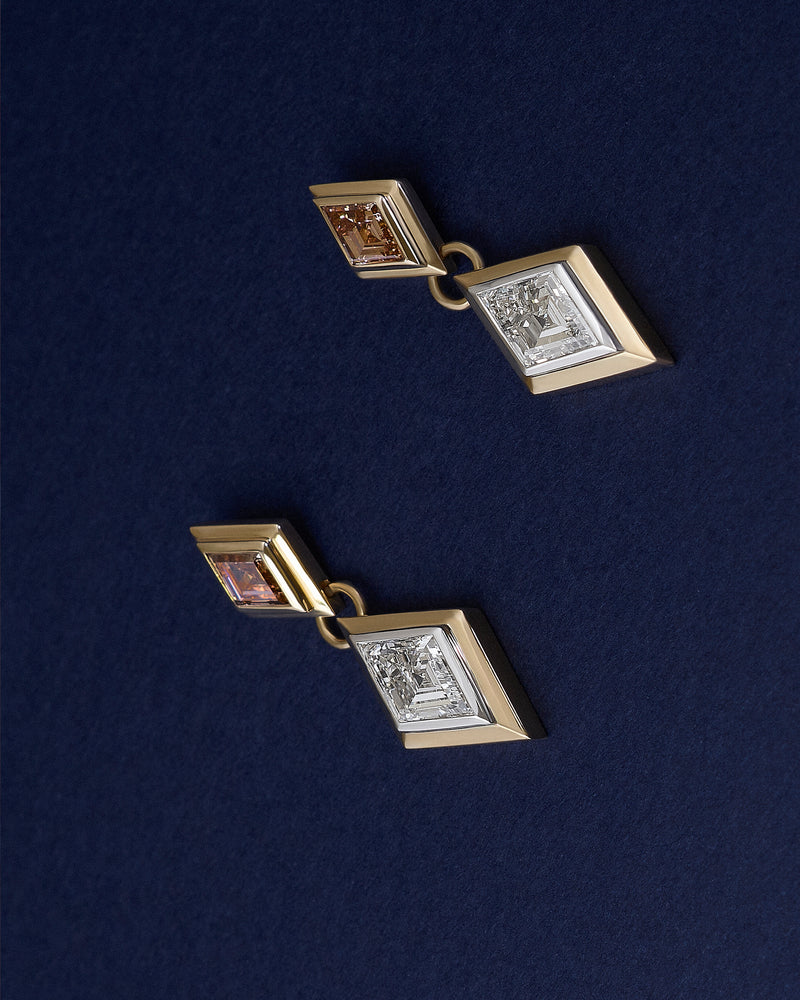 Pair of 18k solid yellow and white gold drop earrings with lozenge lab diamonds on a dark blue background