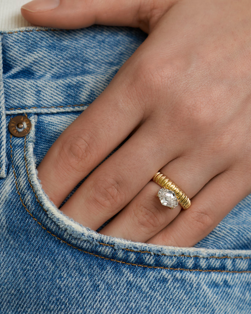 Hand wearing a LEIL signature Auri architectural ring in 18k solid yellow gold with a spike lab diamond on a denim pocket