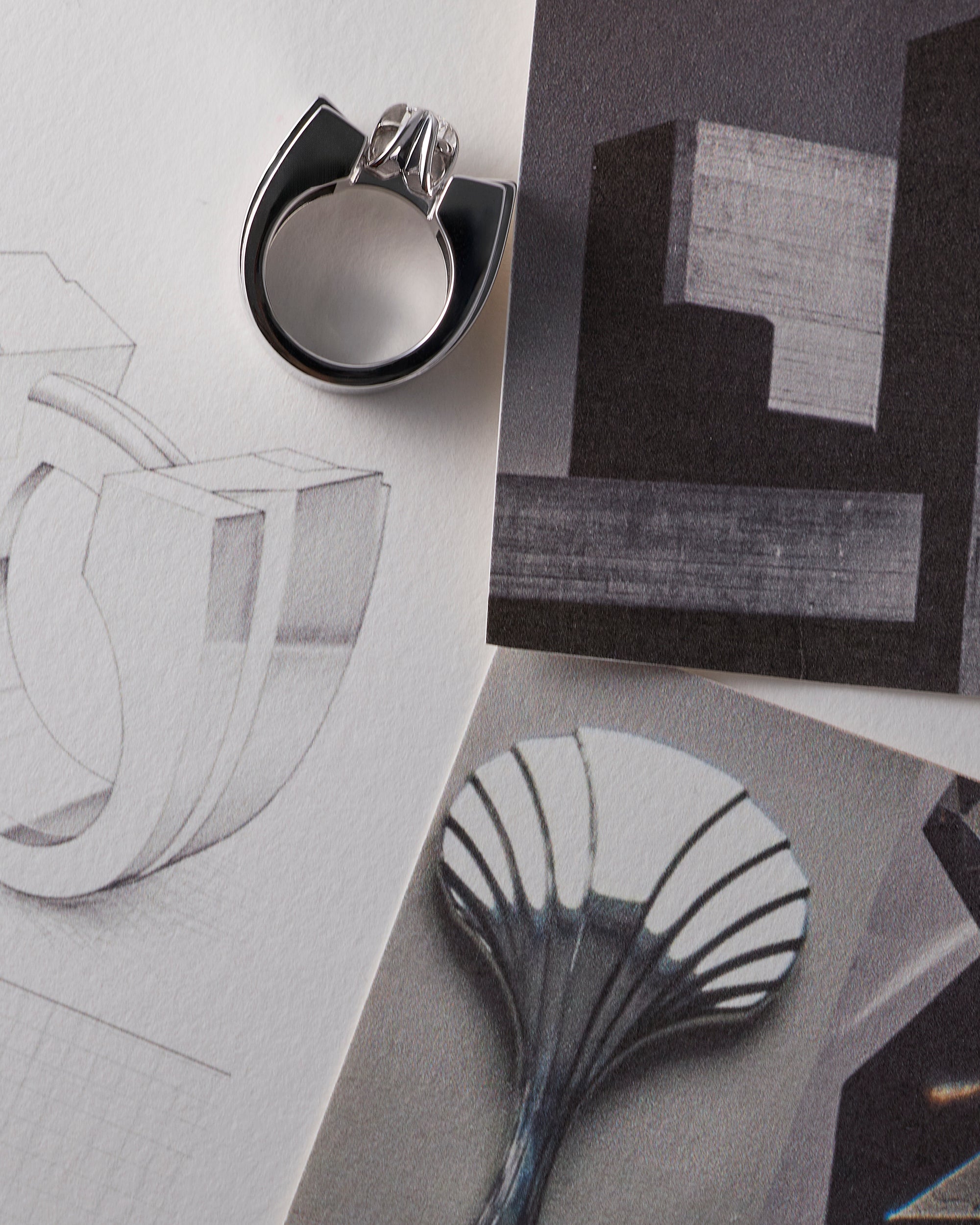Making of a bespoke LEIL 18k white gold ring on a surface with architectural drawings and moodboards